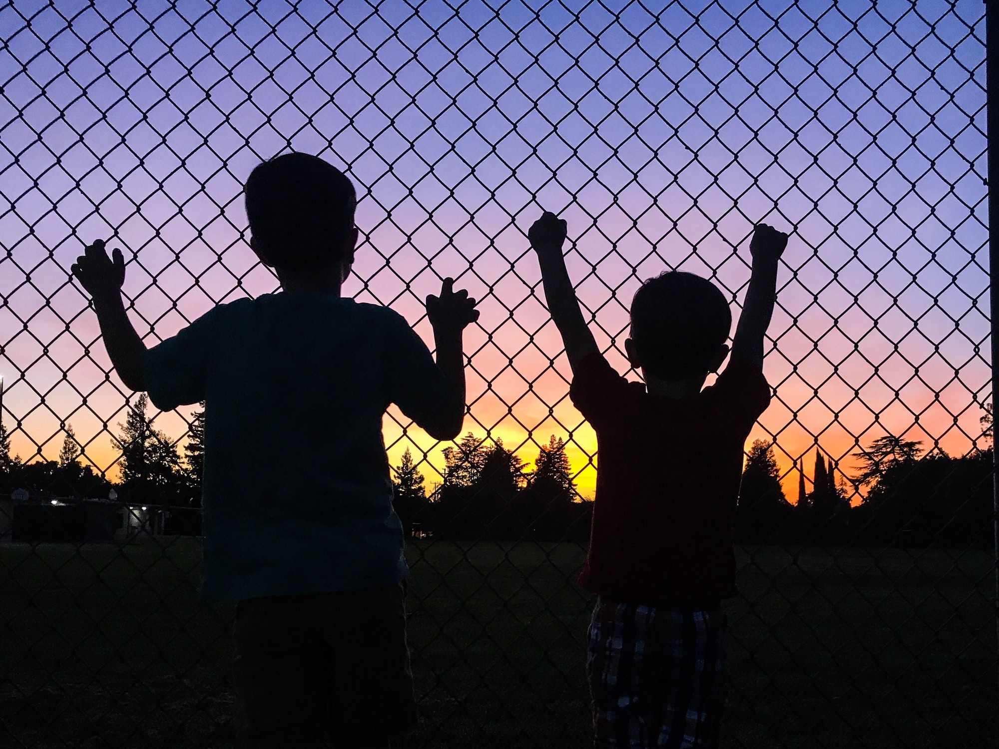 Brothers watching the sunset at the neighborhood park.